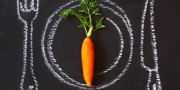 Healthy food concept. Fresh organic carrot on a chalk painted plate.