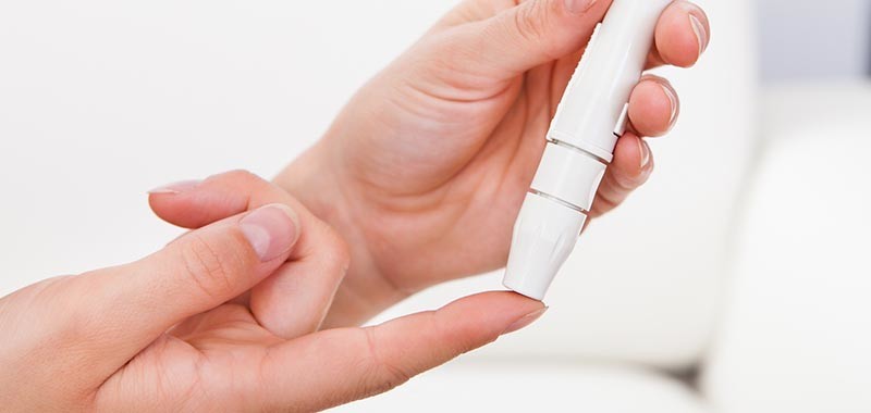 Close-up Of Hand Holding Sugar Level Checking Machine