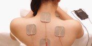 Asian woman is doing massage of electrical -stimulation ( TENs ) for the back