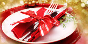Red and gold themed holiday dinner table plate setting