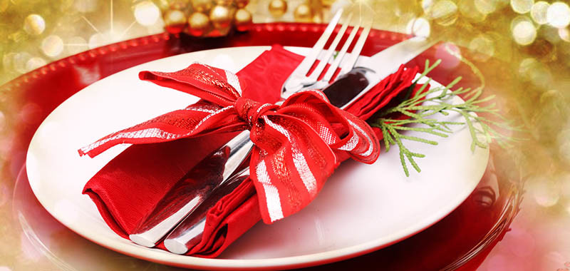 Red and gold themed holiday dinner table plate setting