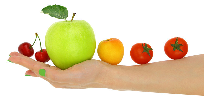 Female hand with a row of fresh colorful fruits